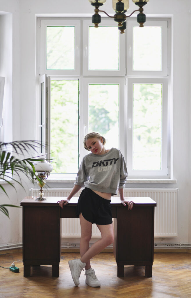 girl in sweatshirt in mid-century apartment